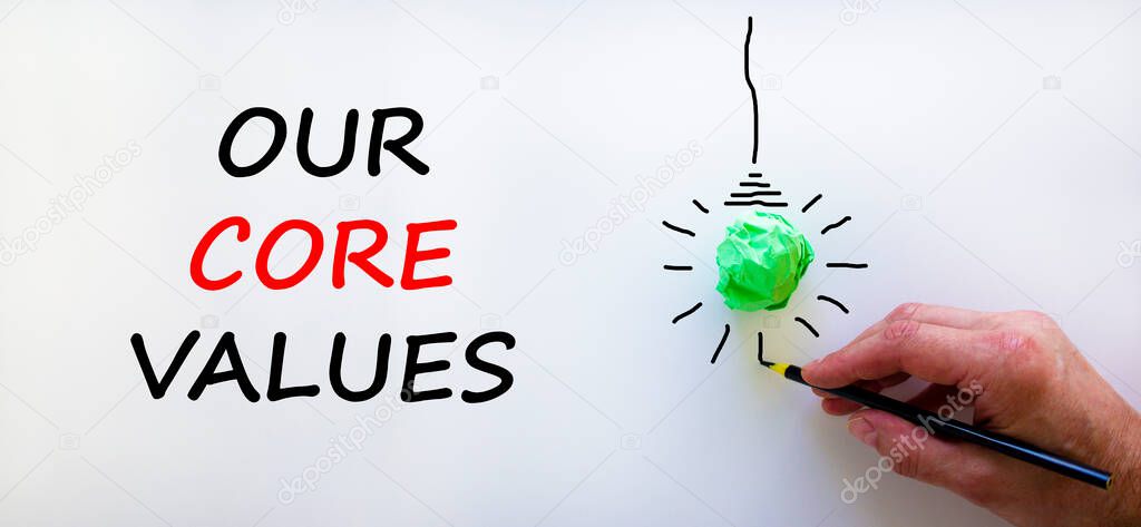 Our core values symbol. Businessman writing words 'Our core values', isolated on beautiful white background. Light bulb icon. Business and our core values concept. Copy space.