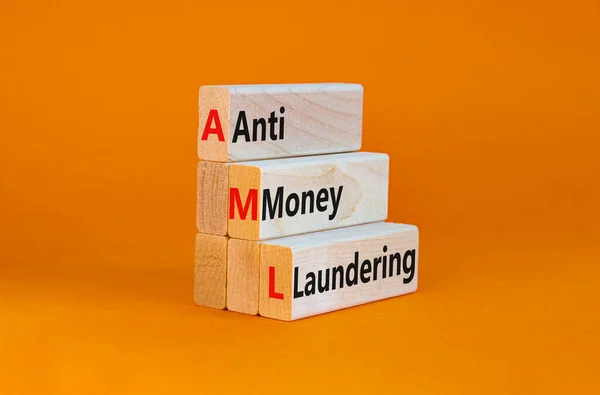 AML, anti-money laundering symbol. Wooden blocks with words AML, anti-money laundering on beautiful orange background. Business, AML, anti-money laundering concept.