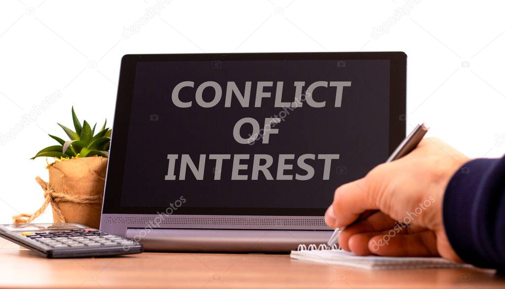 Conflict of interest symbol. Tablet with words 'Conflict of interest'. Businessman hand with pen, house plant. Beautiful white background. Business, conflict of interest concept, copy space.