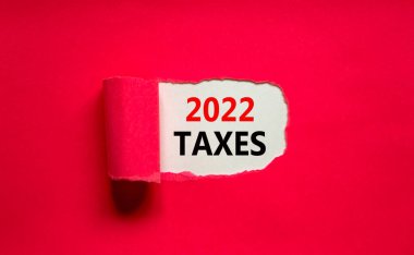 2022 yeni yıl vergisi sembolü. Yırtık mor kağıdın arkasında 2022 vergileri görünüyor. Güzel mor arka plan. İş, 2022 vergi yeni yıl konsepti, kopyalama alanı.