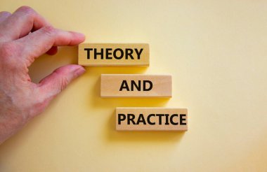 Teori ve pratik sembolü. Güzel beyaz bir arka planda 'Teori ve uygulama' kelimeleriyle tahta bloklar. İşadamı eli. İş, teori ve uygulama konsepti. Boşluğu kopyala.