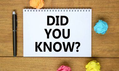 Sembolü biliyor muydun? Güzel ahşap masa, renkli kağıt, siyah metal kalem üzerinde 