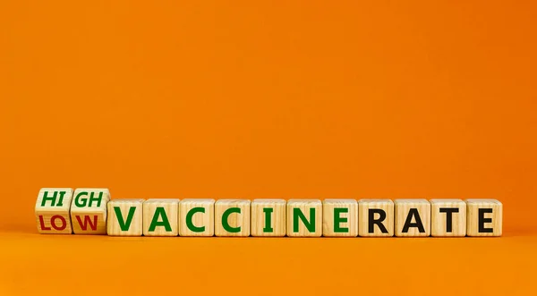 High or low vaccine rate symbol. Turned wooden cubes, changed words \'low vaccine rate\' to \'high vaccine rate\'. Beautiful orange background, copy space. Medical, covid-19 pandemic vaccine rate concept.