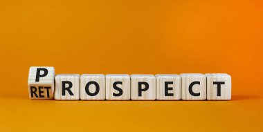 Prospect ya da retrospect sembolü. Küpü döndürdü ve 'retrospekt' kelimesini 'prospect' olarak değiştirdi. Güzel turuncu arka plan. İş ve beklenti ya da geçmişe bakış konsepti. Boşluğu kopyala.