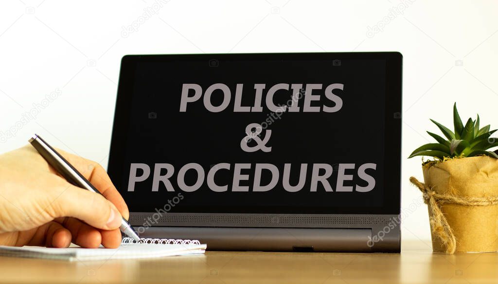 Policies and procedures symbol. Tablet with words 'Policies and procedures'. Businessman hand with pen, house plant. Beautiful white background. Business, policies and procedures concept, copy space.