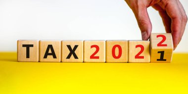 2022 yılbaşı vergisi sembolü. İşadamı ahşap küpleri değiştiriyor ve 