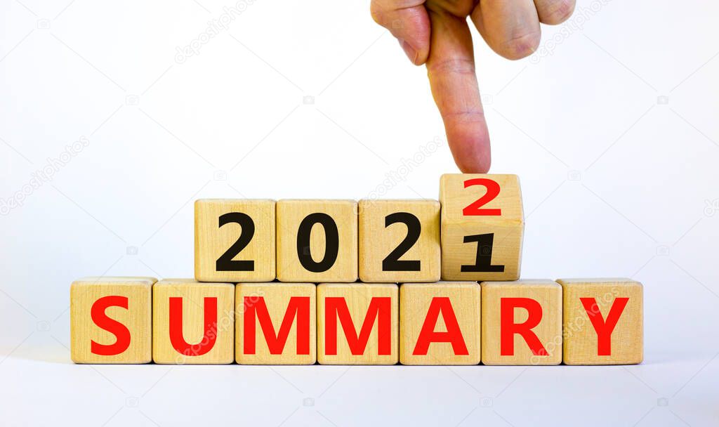 Symbol of planning 2022 summary new year. Businessman turns a wooden cube and changes words 'summary 2021' to 'summary 2022'. Beautiful white background, copy space. Business, 2022 summary concept.