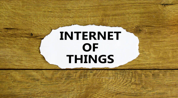 IOT, internet of things symbol. Words 'IOT, internet of things' on white paper. Beautiful wooden background. Business, digital, IOT, internet of things concept.