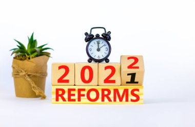 2022 reformunun yeni yıl planlama sembolü. Çalar saat. Tahta bir küp yaptı, 'reformlar 2021' i 'reformlar 2022' olarak değiştirdi. Güzel beyaz arka plan, kopyalama alanı. İş dünyası, 2022 reform kavramı.