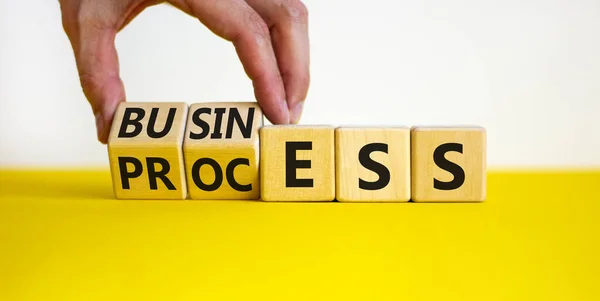 Success business process symbol. Businessman turns wooden cubes with words 'business process'. Beautiful white background, copy space. Success business process concept.