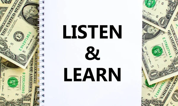 Listen and learn symbol. Words \'Listen and learn\' on white note. Beautiful background from dollar bills. Business, educational and listen and learn concept. Copy space.