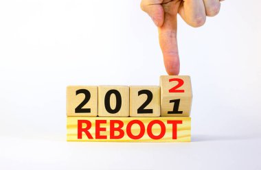 2022 yeni yıl sembolünü yeniden başlat. İşadamı ahşap küpü çeviriyor ve '2021' i yeniden başlat 'kelimesini' 2022 'olarak değiştiriyor. Güzel beyaz arka plan, kopyalama alanı. İş, 2022 Yeni Yıl Konseptini Yeniden Başlat.