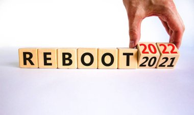 2022 yeni yıl sembolünü yeniden başlat. İşadamı ahşap küpleri değiştirip '2021' i yeniden başlat 'kelimesini' 2022 'olarak değiştiriyor. Güzel beyaz arka plan, kopyalama alanı. İş, 2022 Yeni Yıl Konseptini Yeniden Başlat.