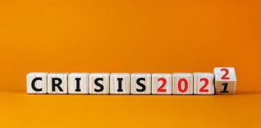 2022 krizi ve yeni yıl sembolü. Tahta bir küp yaptı ve 'kriz 2021' kelimesini 'kriz 2022' olarak değiştirdi. Güzel turuncu arkaplan, kopyalama alanı. İş, 2022 krizi ve yeni yıl konsepti.