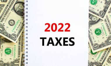 2022 yeni yıl vergisi sembolü. Sözcükler '2022 vergi', beyaz notla. Dolar banknotlarından güzel bir geçmiş. İş ve 2022 vergi yeni yıl konsepti. Boşluğu kopyala.