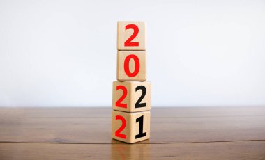 2022 mutlu yeni yıl sembolü. Bir küpü dönüştürmek, 2021 'den 2022' ye değişimi sembolize ediyor. Güzel beyaz arka plan. Uzayı kopyala İş ve 2022 Mutlu yıllar konsepti.