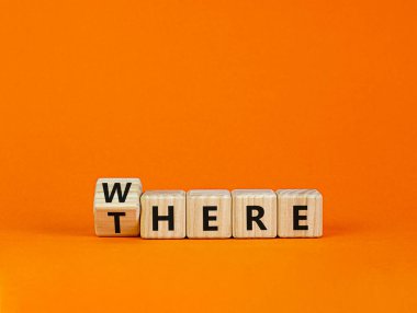 Orada ya da nerede sembolü. Tahta bir küp yaptı, 'orada' kelimesini 'nerede' olarak değiştirdi. Güzel turuncu masa, turuncu arka plan, fotokopi alanı. İş, orada ya da nerede.