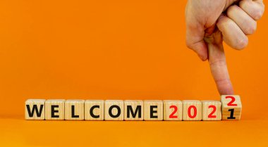 2022 planlama sembolü yeni yıla hoş geldin. İş adamı ahşap küpü değiştiriyor ve 