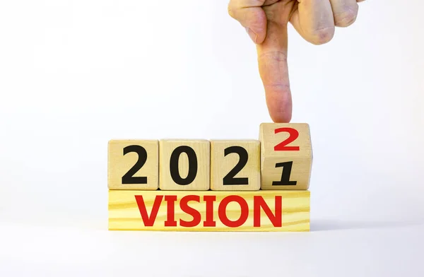 2022ビジョン新年のシンボル ビジネスマンは木製のキューブを回し ビジョン2021 ビジョン2022 に変更します 美しい白い背景 コピースペース ビジネス 2022ビジョン新年のコンセプト — ストック写真
