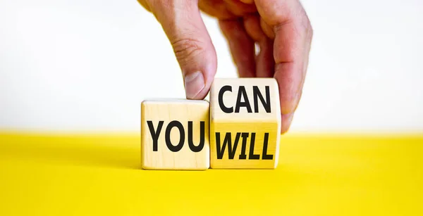 stock image You can and will symbol. Businessman turns a cube and changes words you can to you will. Beautiful white and yellow background, copy space. Business, motivational and you can and will concept.