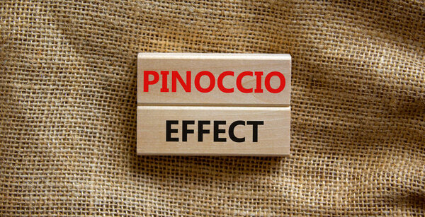 Pinoccio effect symbol. Concept words Pinoccio effect on wooden blocks on a beautiful canvas background. Business and Pinoccio effect concept, copy space.