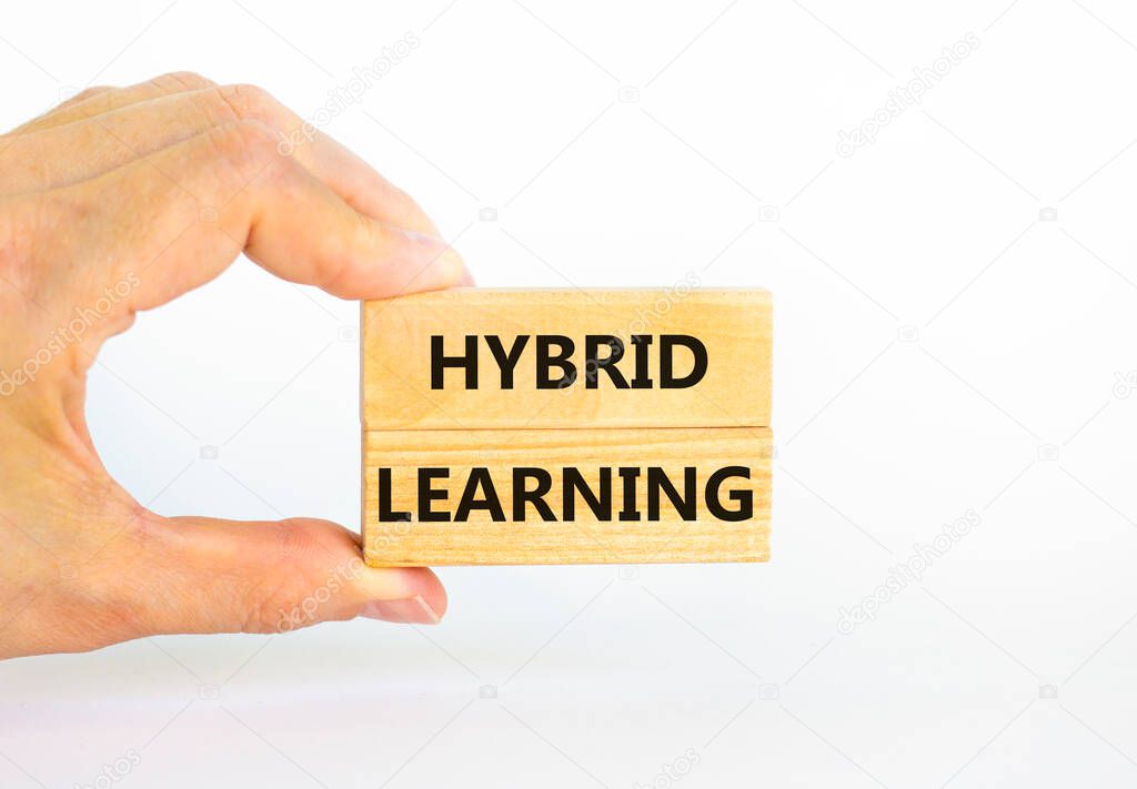 Hybrid learning symbol. Concept words 'Hybrid learning' on wooden blocks on a beautiful white background. Businessman hand. . Business, educational and hybrid learning concept, copy space.