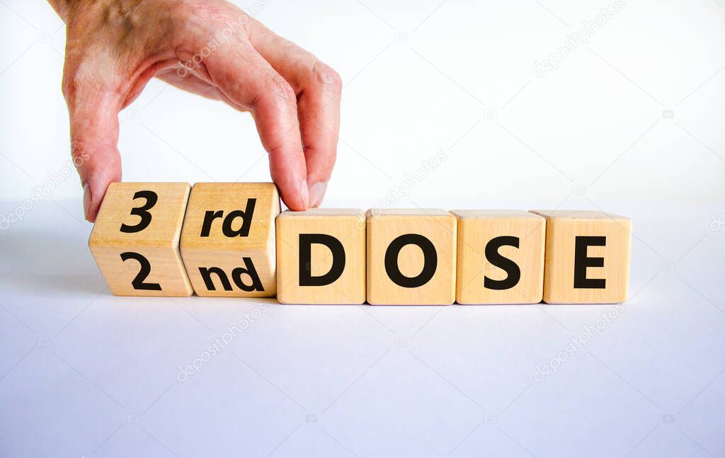Covid-19 booster dose vaccine shot symbol. Doctor turns cubes and changes words '2nd dose' to '3rd dose'. Beautiful white background, copy space. Covid-19 booster dose vaccine shot concept.
