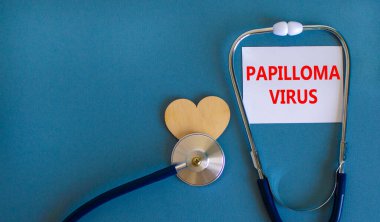 Papilloma virüsü sembolü. Üzerinde Papilloma virüsü yazan beyaz kart, güzel mavi arka plan, tahta kalp ve stetoskop. Tıbbi ve papilloma virüsü kavramı.
