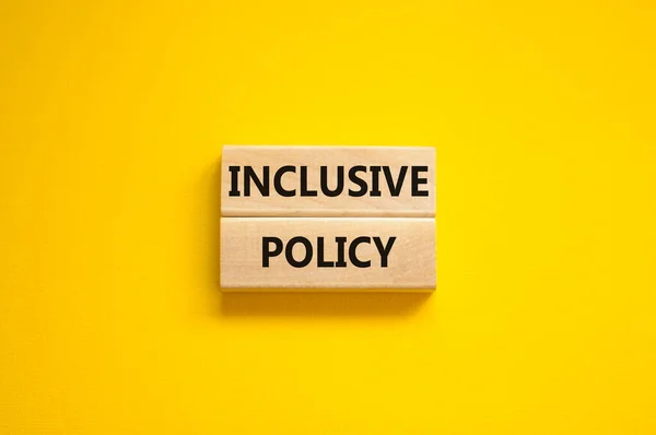 Inclusive policy symbol. Wooden blocks with words Inclusive policy on beautiful yellow background. Business, HR and inclusive policy concept. Copy space.