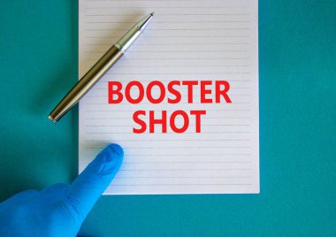 Covid-19 aşı aşısı sembolü. Beyaz nota, destekleyici çekimler, güzel mavi arka plan, doktor eli ve metalik kalem. Covid-19 destek aşısı konsepti.