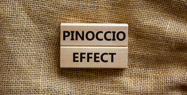 Pinoccio effect symbol. Concept words Pinoccio effect on wooden blocks on a beautiful canvas background. Business and Pinoccio effect concept, copy space.
