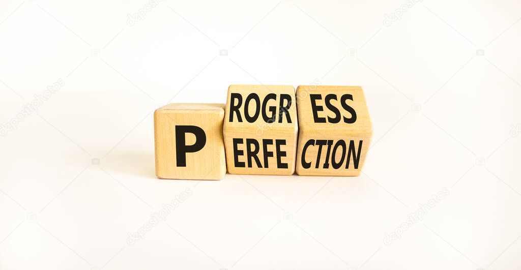 Progress or perfection symbol. Turned wooden cubes and changed the concept word 'perfection' to 'progress' on a beautiful white background. Copy space. Business and progress or perfection concept.