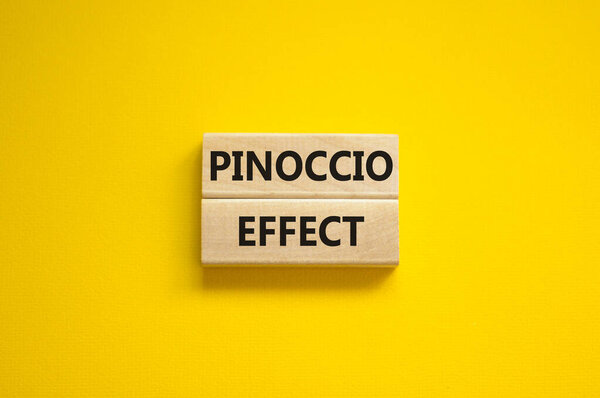 Pinoccio effect symbol. Concept words Pinoccio effect on wooden blocks on a beautiful yellow background. Business and Pinoccio effect concept, copy space.