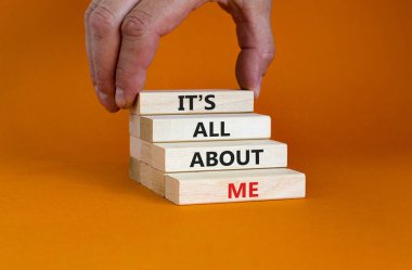 It is all about me symbol. Wooden blocks with words 'It is all about me'. Beautiful orange background. Businessman hand. Copy space. Business and it is all about me concept. clipart