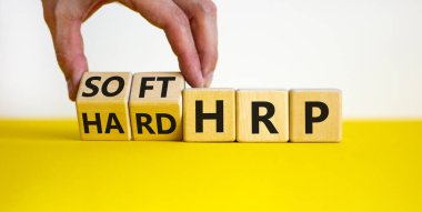 HRP, insan kaynakları planlama sembolü. İşadamı ahşap küpleri değiştirip sert HRP 'yi yumuşak HRP' ye çeviriyor. Güzel beyaz arka plan. İş, HRP, insan kaynakları planlaması. Boşluğu kopyala.