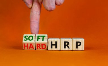 HRP, insan kaynakları planlama sembolü. İşadamı ahşap küpleri değiştirip sert HRP 'yi yumuşak HRP' ye çeviriyor. Güzel turuncu arka plan. İş, HRP, insan kaynakları planlaması. Boşluğu kopyala.