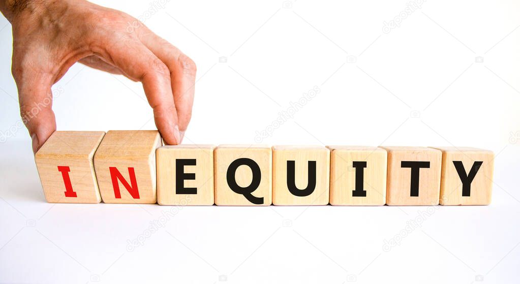 Inequity or equity symbol. Businessman turns wooden cubes and changes the word inequity to equity. Business and inequity or equity concept. Beautiful white background, copy space.