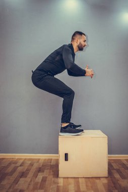 Genç kaslı adam atlayışı mükemmelleştiriyor. Crossfit eğitimi. Crossfit stil jimnastik salonunda atlayan adam kutusu.
