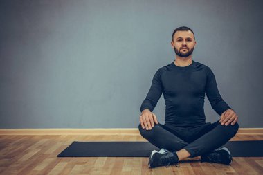 Lotus yogası pozunda oturan adam. Sabah rutini. Öğretmen fitness stüdyosu. Asana sınıfı. Çevrimiçi egzersiz. Kapalı alanda rahatlama. Erkek duası..