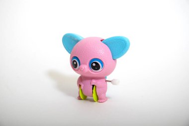 Beyaz arka planda izole edilmiş gölge yansımalı gül hayvan oyuncağı. Gökkuşağı renkli plastik oyuncak. Serçe parmak şirin.