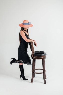 Retro tarzı görüntü. Koyu renk elbiseli, genç ve güzel bir kadının tam portresi..