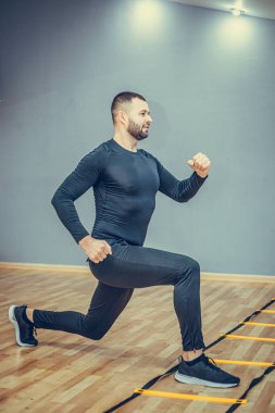 Fitness konsepti. Spor salonunda koşan yakışıklı bir adamın portresi..