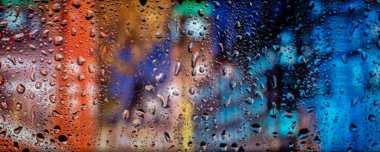 Yağmurlu bir gecede şehir manzarası, yol lambası ile pencereye düşen yağmur. Yağmurlu günler. Sokak manzaralı yağmur damlaları, yağmurlu hava, yağmur arkaplanı.