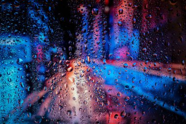 Yağmurlu bir gecede şehir manzarası, yol lambası ile pencereye düşen yağmur. Yağmurlu günler. Sokak manzaralı yağmur damlaları, yağmurlu hava, yağmur arkaplanı.