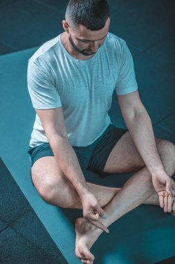 Erkek yogası pozu. Delikanlılar içeride siyah minder üzerinde yoga yapıyor. Spor salonunda siyah bir geçmişi olan yoga yapan bir adam. Nilüfer çiçekleri gibi meditasyon yapan genç adamlar. Eğitim kavramı.