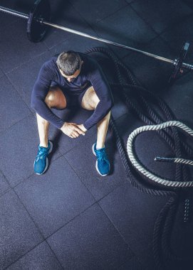 Genç sakallı adam antrenmandan sonra dinleniyor. Spor salonundaki eğitimden sonra dinlenen sağlıklı genç bir erkek. Yüksek resulotion resmi.