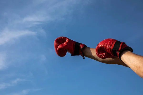 Foto Alta Resolução Mão Masculina Segurando Luvas Boxe Vermelhas Céu — Fotografia de Stock
