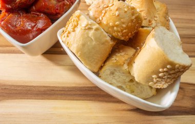 Kurutulmuş domates dolu bir kase. Etrafı susamlı ekmekle çevrili.