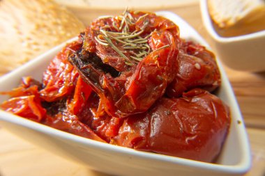 Kurutulmuş domates dolu bir kase. Etrafı susamlı ekmekle çevrili.