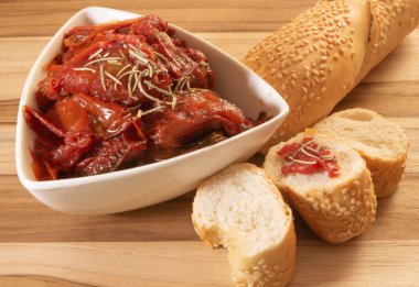 Kurutulmuş domates dolu bir kase. Etrafı susamlı ekmekle çevrili.